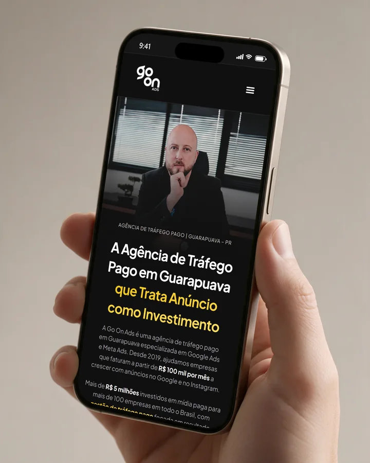 Mão segurando um celular com o site Go On Ads aberto