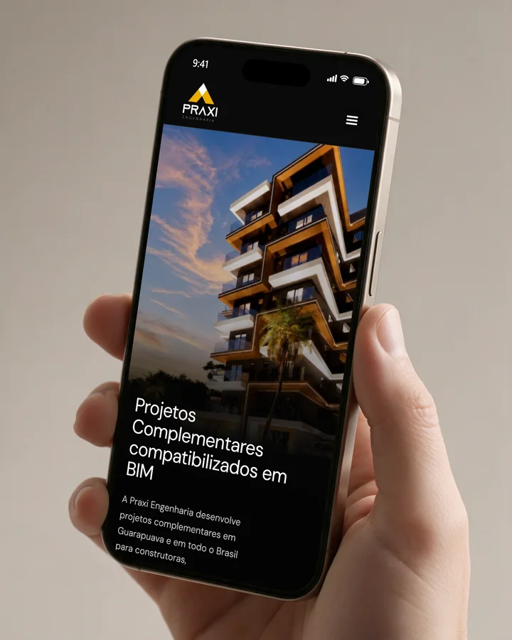Mão segurando um celular com o site Praxi Engenharia aberto